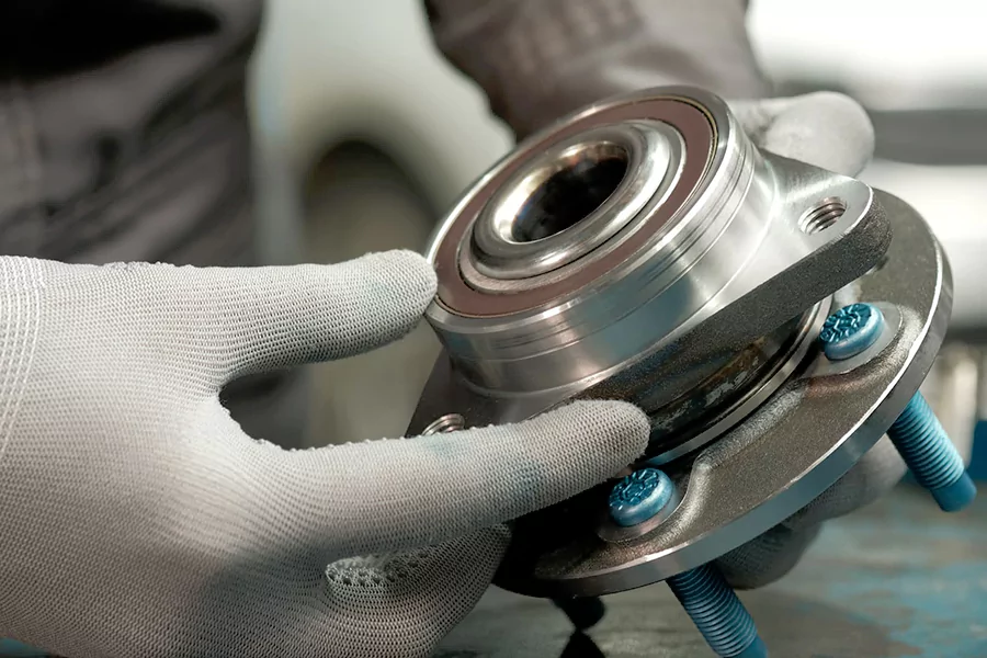 The picture shows a person replacing the wheel hub assembly