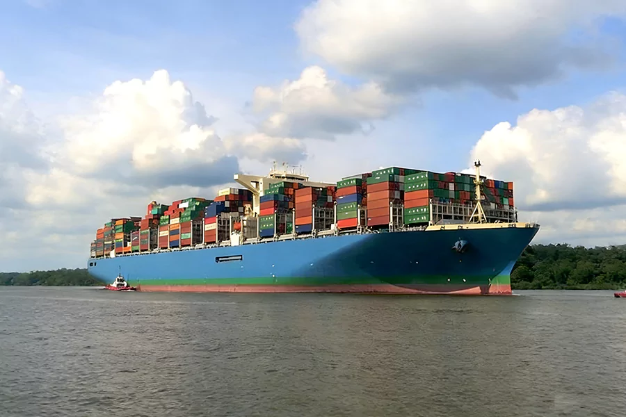 The picture shows a cargo ship sailing on the sea