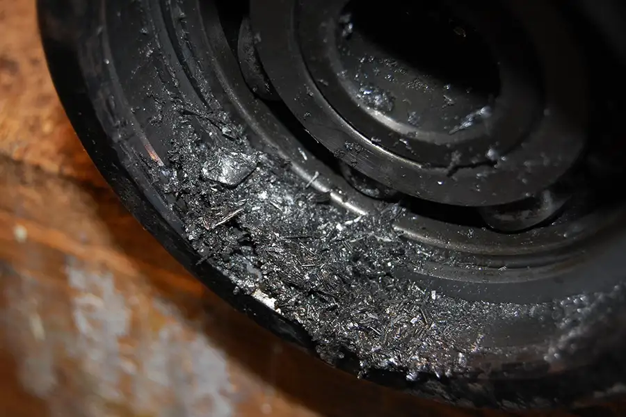 Damaged bearing raceway inside an agricultural hub unit showing wear and metal debris